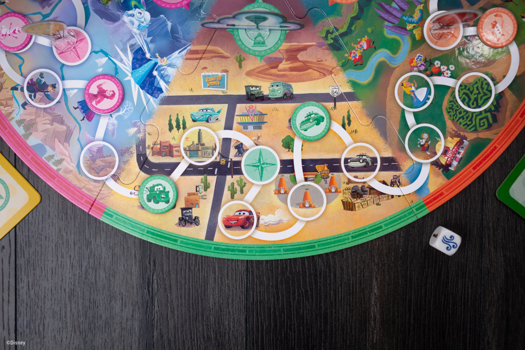 Closeup view of a portion of the game board, as well as some stamp tokens, from the Disney Around the World tabletop game